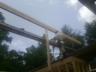 Carpenter setting a ridge beam over a new addition frame — Ice Dam Removal by Roofing Brothers in Wadsworth